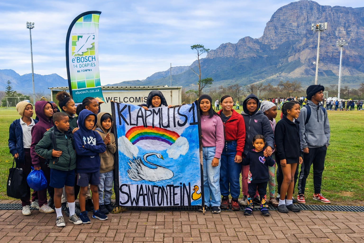 Community members and children at a local event holding a Klapmuts Swahnfontein banner
