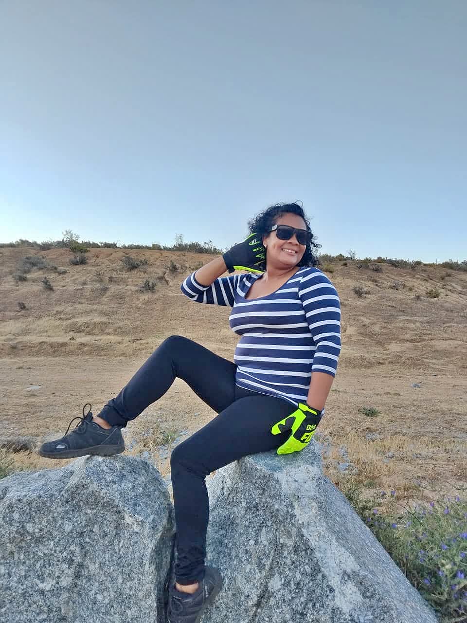 Regina Clarke on a rock outdoors in quadbiking gear